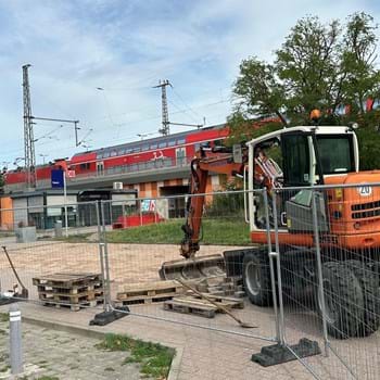 Ein Bagger beginnt mit den ersten Bauarbeiten vor dem Bahnsteigzugang des Nauener Bahnhofs.