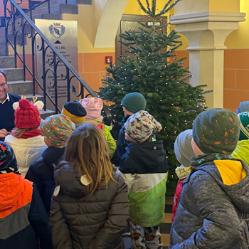 Kinder schmücken gemeinsam mit dem Bürgermeister den Weihnachtsbaum im Rathausfoyer